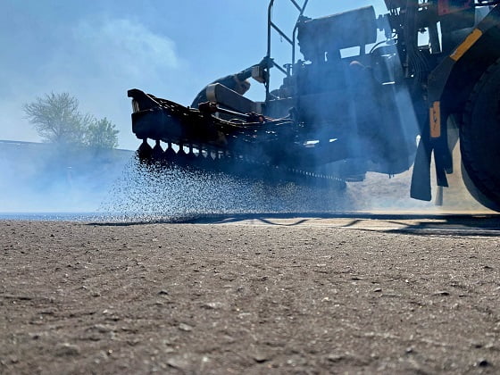 Road Sprayer spraying black bitumen onto new road surface